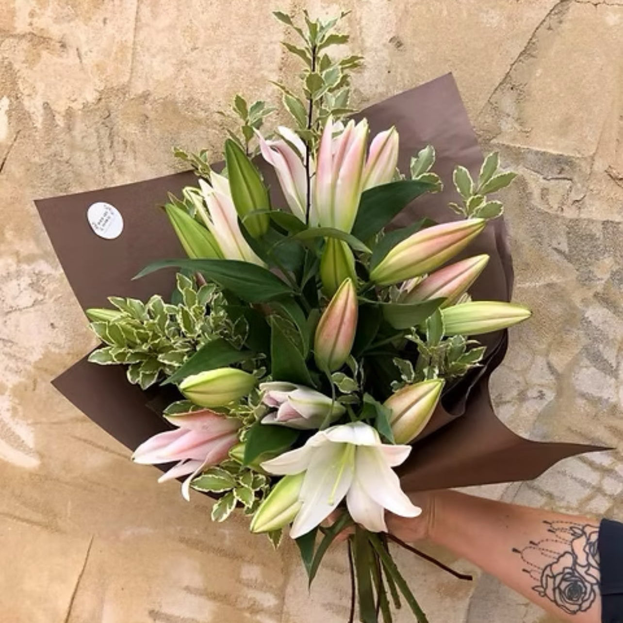 Stunning bouquet of long-stemmed Oriental lilies from WA, elegantly wrapped in brown paper and mesh with a jute tie.